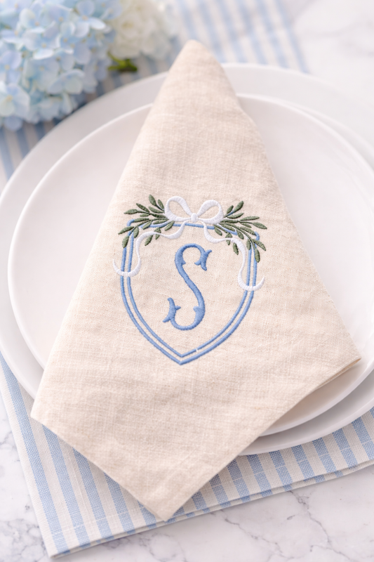 Napkin with embroidered design on a white plate with blue stripes