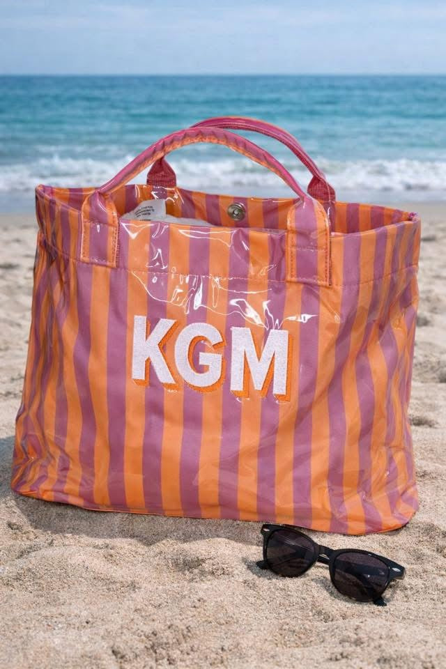 Striped bag with 'KGM' on a beach