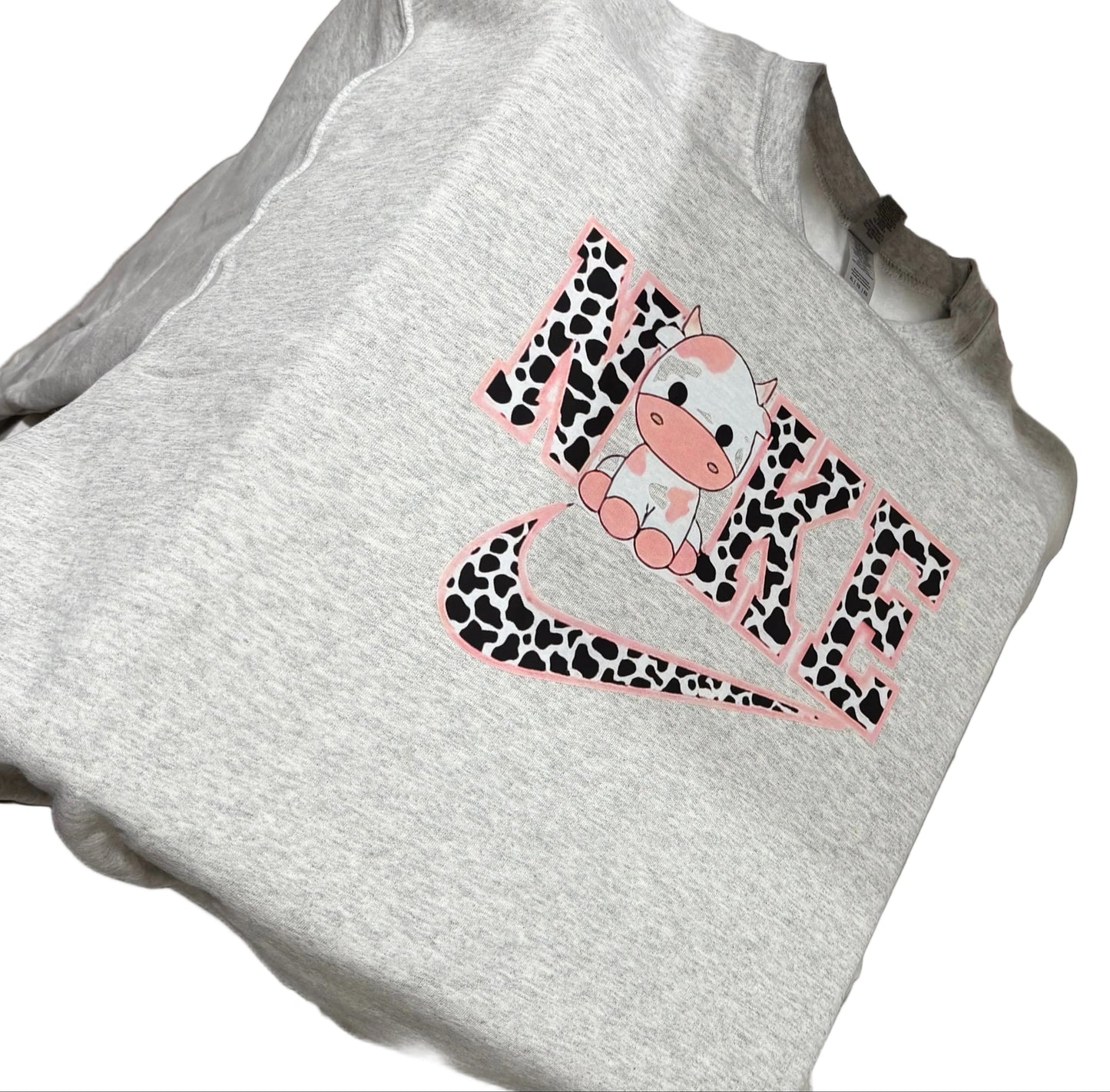 White t-shirt with a pink and black design on a sewing machine.