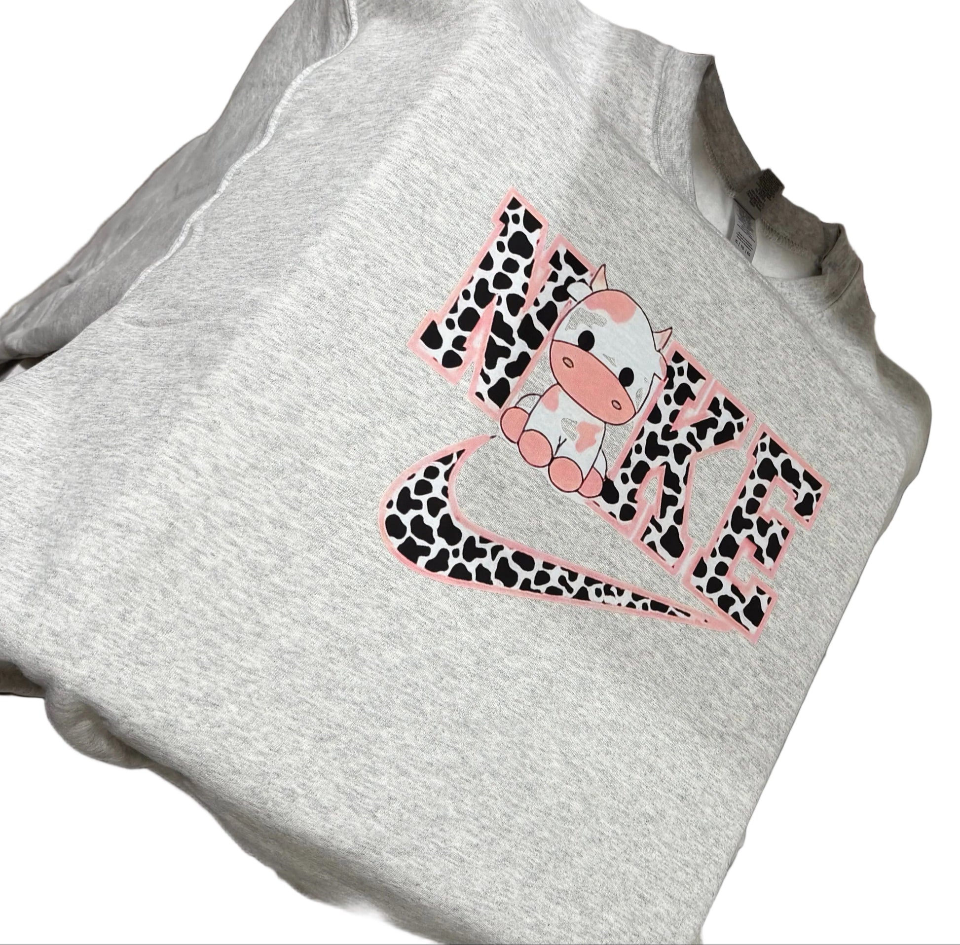White t-shirt with a pink and black design on a sewing machine.