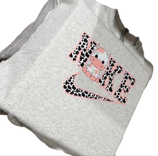 White t-shirt with a pink and black design on a sewing machine.