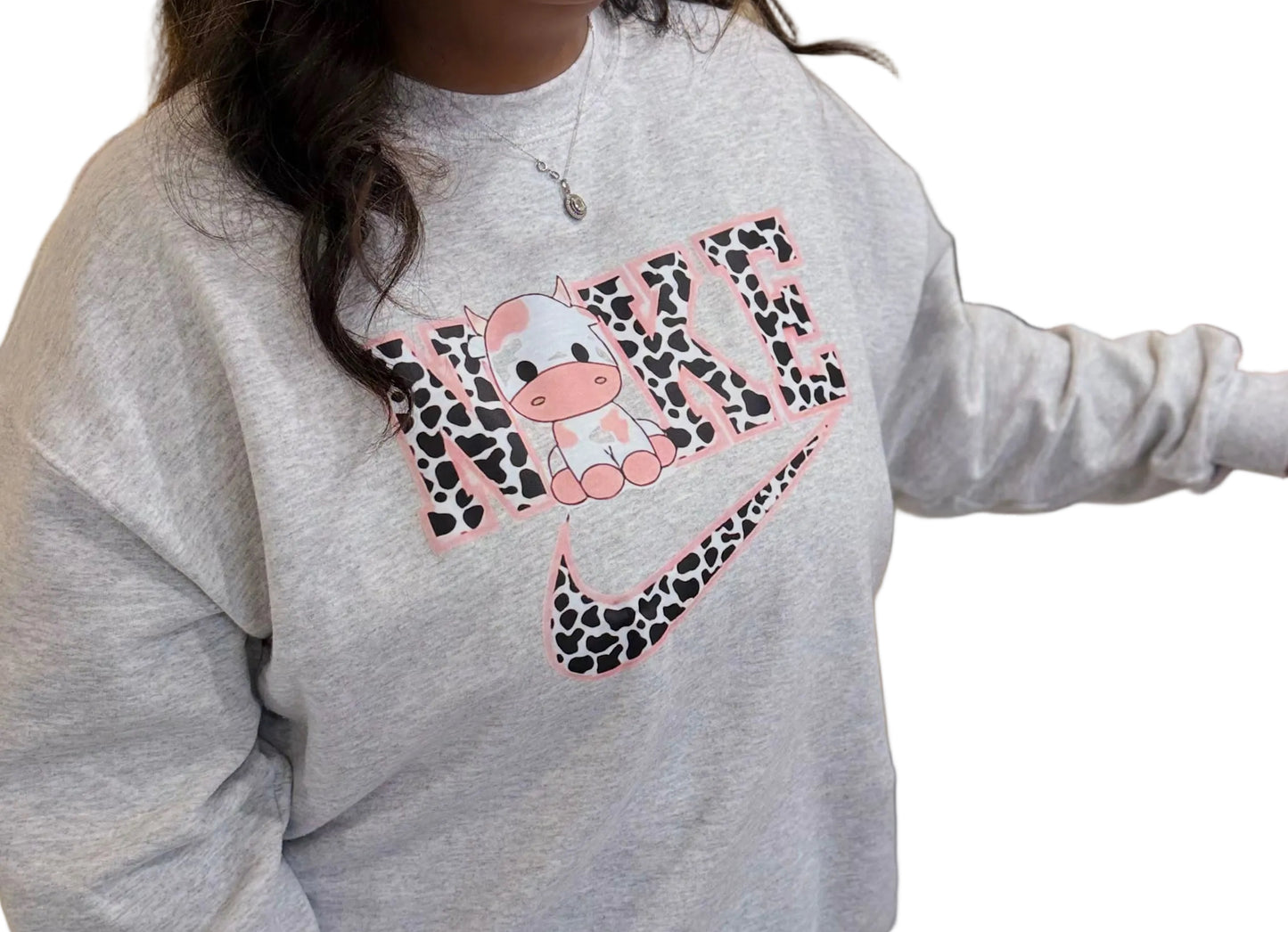 Person wearing a gray sweatshirt with a colorful design, standing indoors.