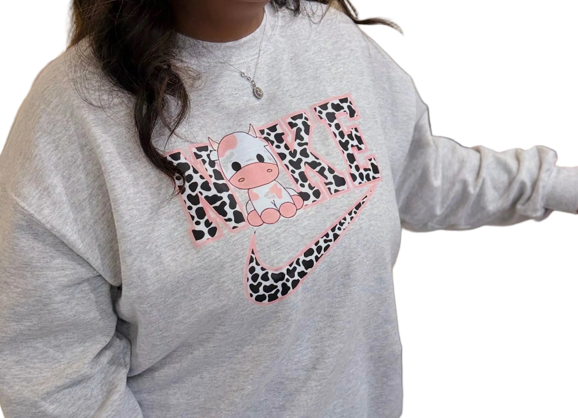 Person wearing a gray sweatshirt with a colorful design, standing indoors.