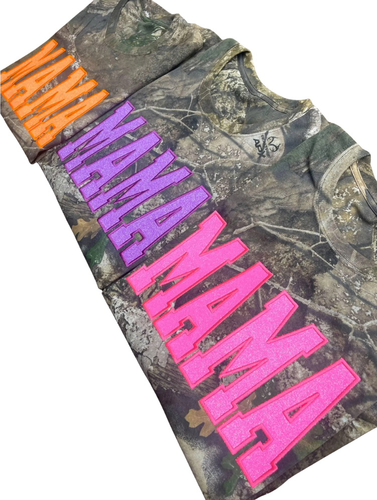 Camouflage shirt with colorful text 'MAMA' on a white background