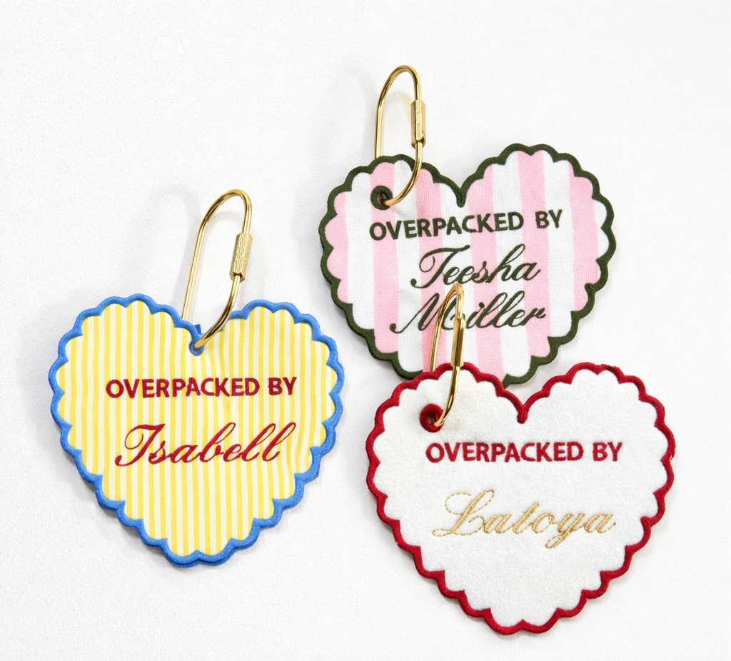 Colorful luggage tags with personalized names on a suitcase.