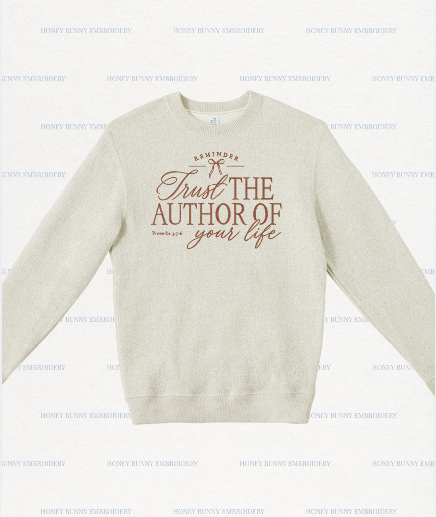 A light beige crewneck sweatshirt with a brown graphic print on the front reading 'Trust THE AUTHOR OF your life' and 'REMINDER' with a small bow illustration. The sweatshirt is displayed flat against a white background with a repeating 'HONEY BUNNY EMBROIDERY' watermark pattern.